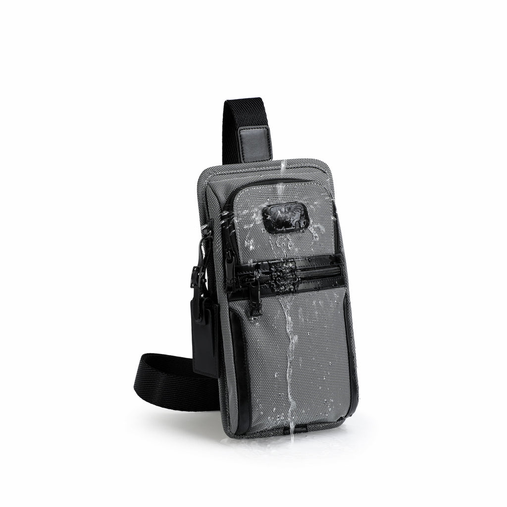 A gray and black waterproof sling bag with a transparent front pocket, shown on a clean white background with water droplets dripping off it to demonstrate its water-resistant feature.