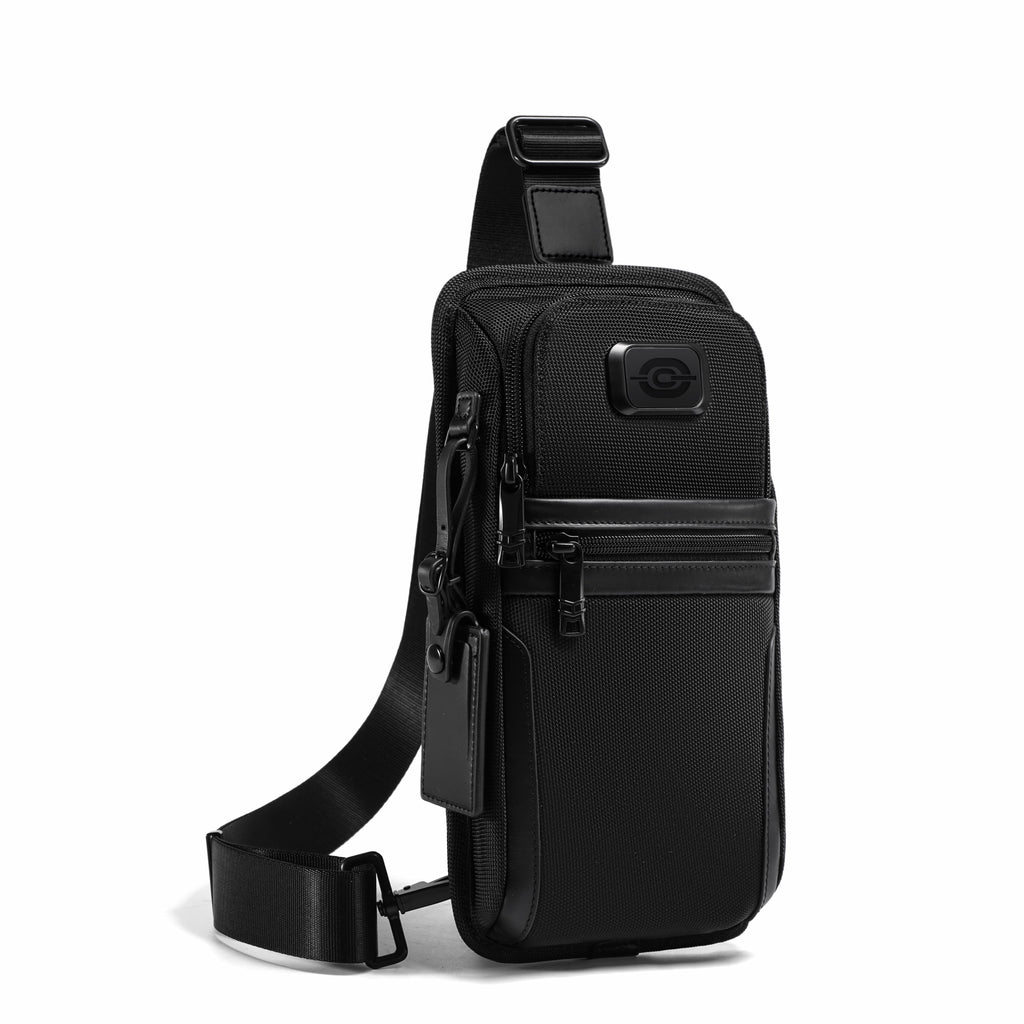 A black sling backpack with a single shoulder strap, multiple zippered pockets, and a small circular logo patch on the front, shown on a plain white background.