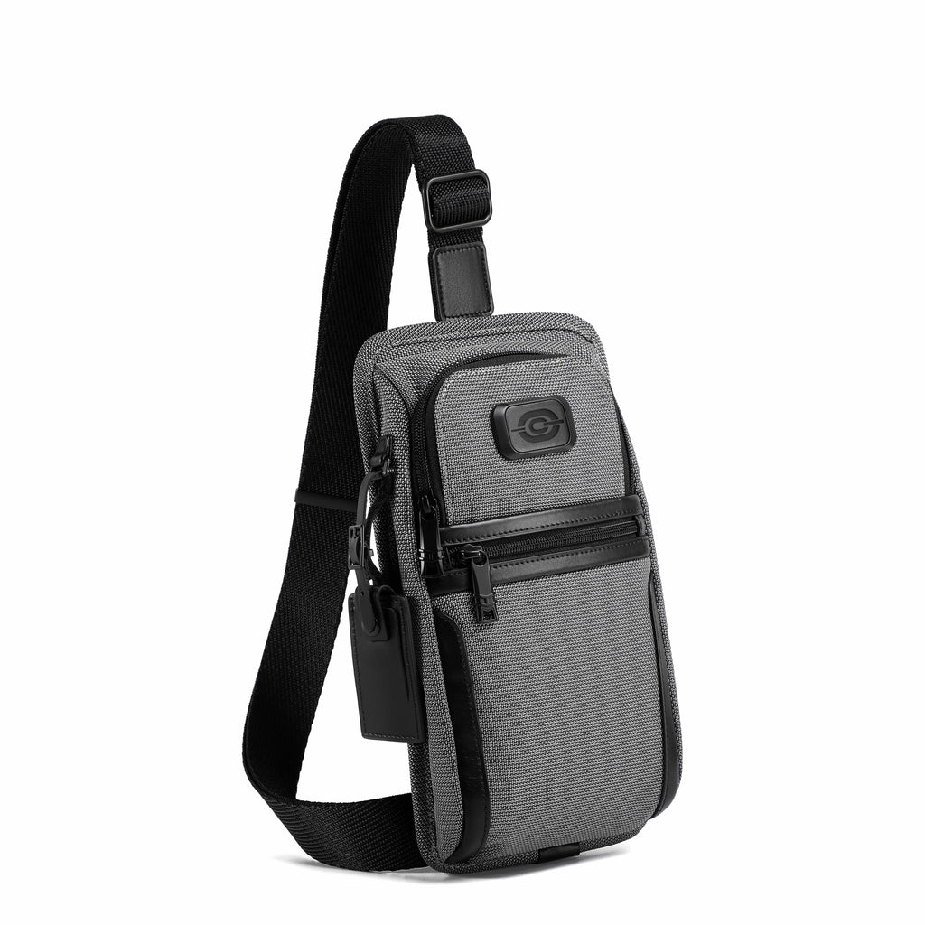 A gray and black crossbody phone bag with a textured pattern, featuring a black adjustable strap and a small circular logo patch on the front pocket, shown against a plain white background.