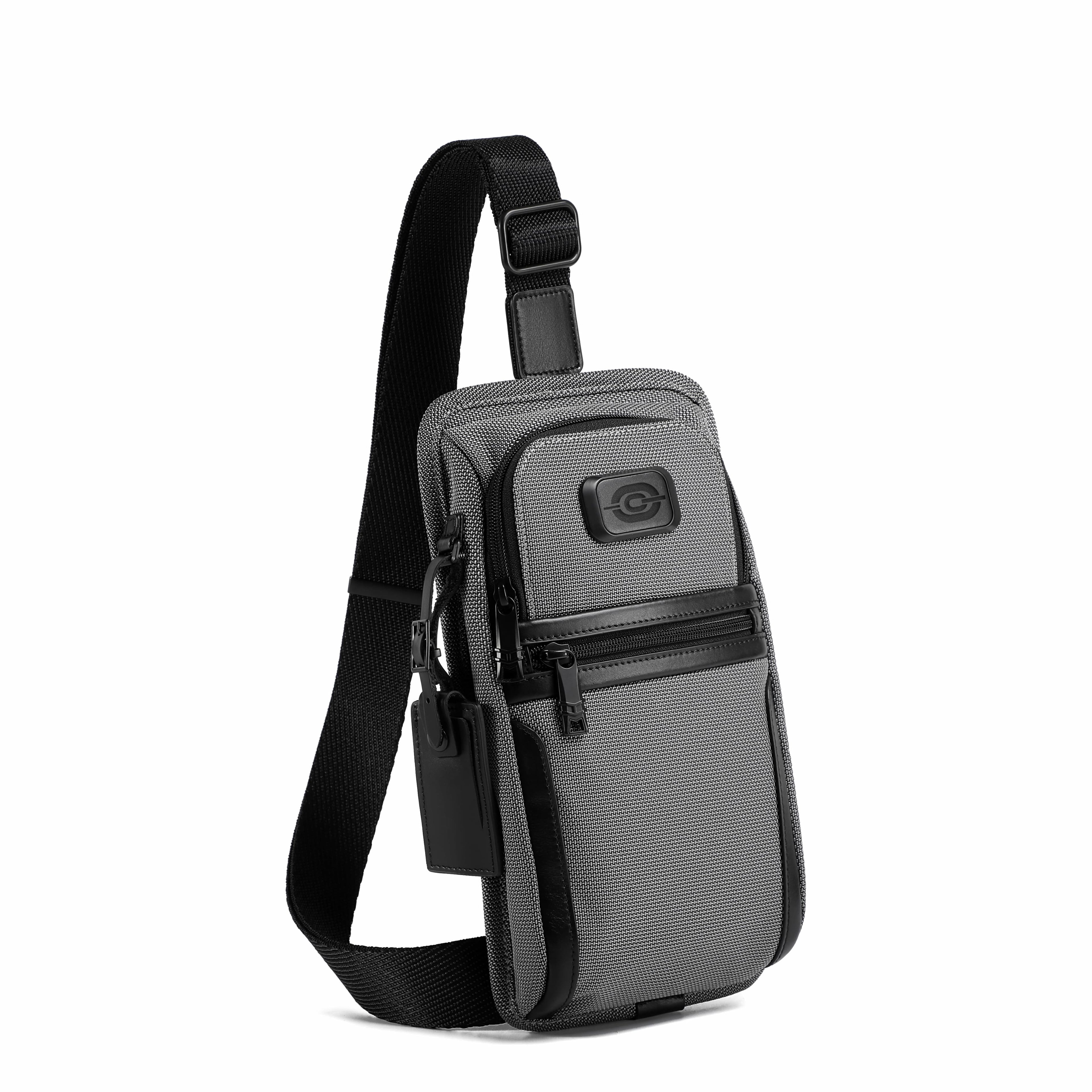 A gray and black crossbody phone bag with a textured pattern, featuring a black adjustable strap and a small circular logo patch on the front pocket, shown against a plain white background.