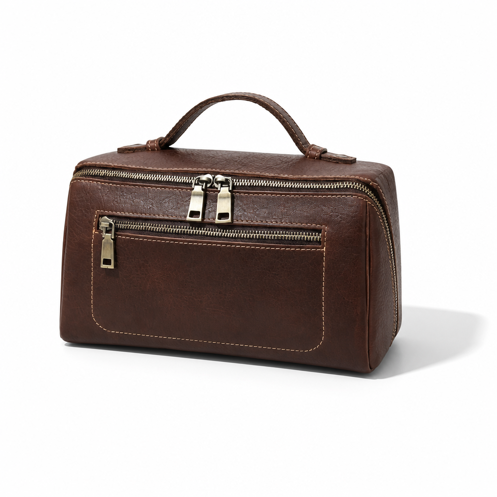 A dark brown faux-leather travel toiletry bag with a top handle, a front zippered pocket, and a top zip closure, shown on a white background with a soft shadow.