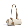 Beige handbag with brown leather straps on a white background