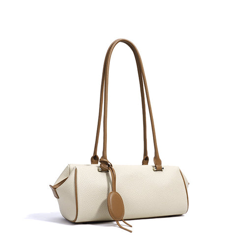 Beige handbag with brown leather straps on a white background