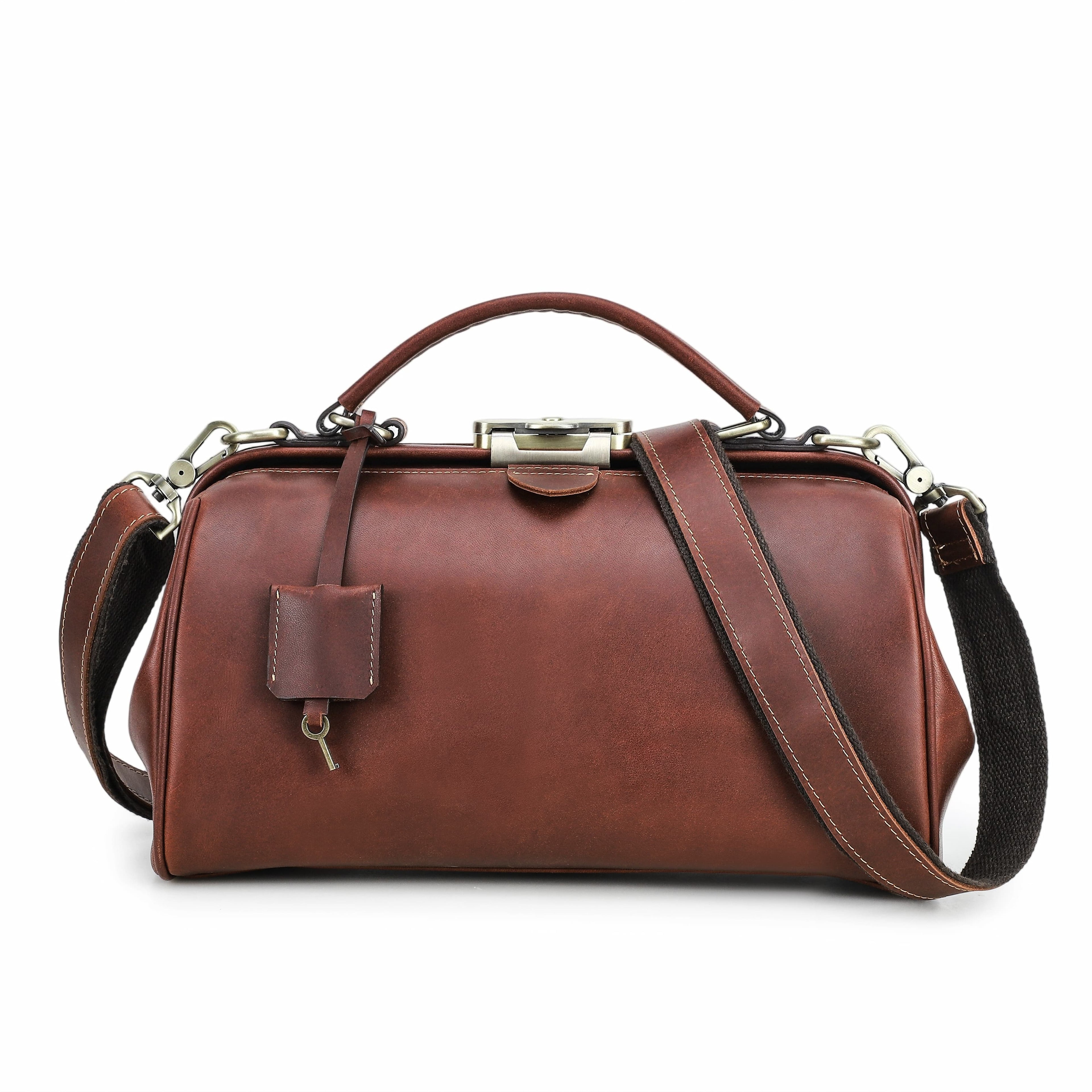 A brown leather top-handle satchel with a detachable shoulder strap, silver-tone hardware, and a small hanging tag, shown on a plain white background.