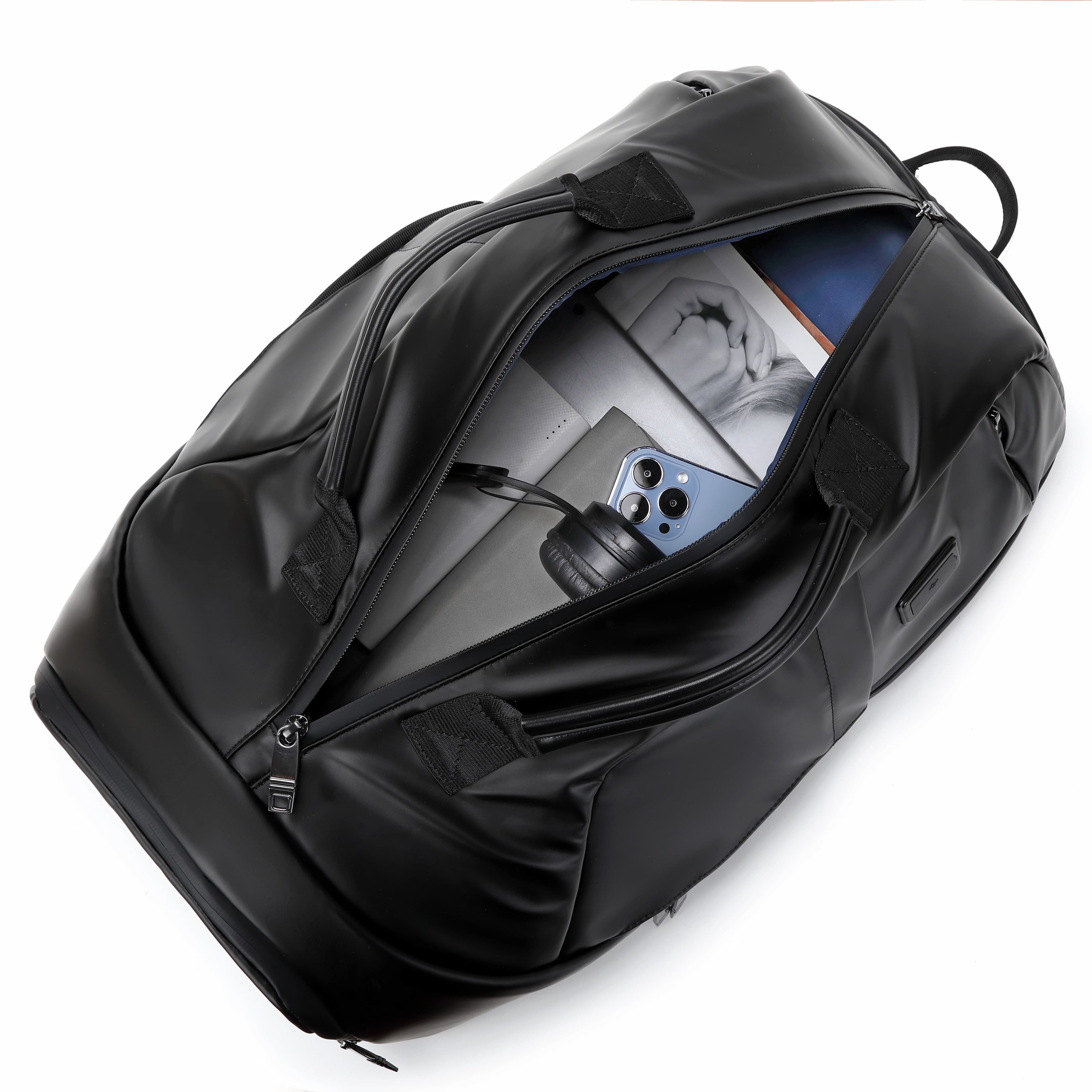 A black duffel bag shown open on a white background, with a phone and magazine visible inside.