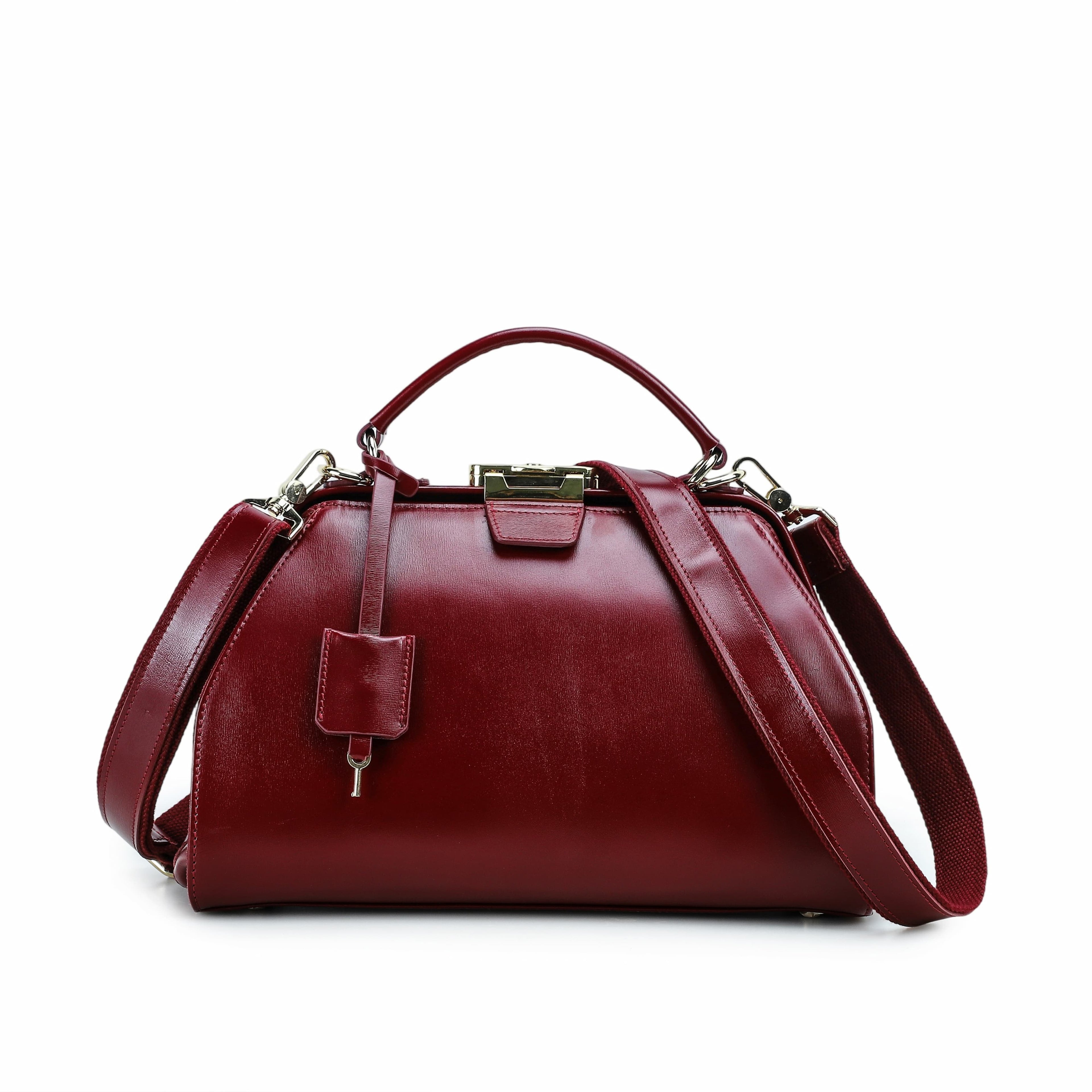 A burgundy leather handbag with a top handle, detachable shoulder strap, and gold-tone hardware, shown against a plain white background.