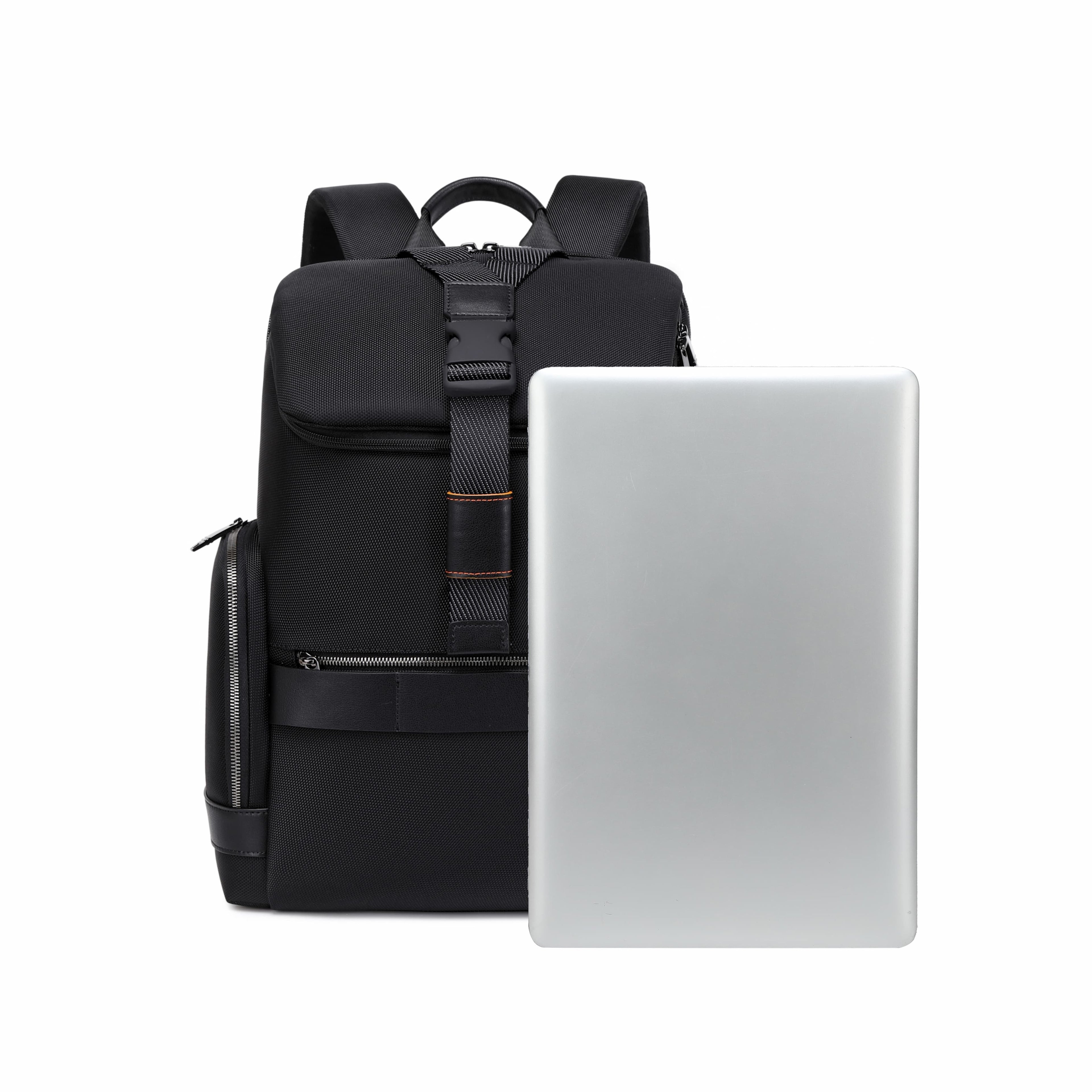 A black backpack standing upright next to a closed silver laptop on a plain white background.