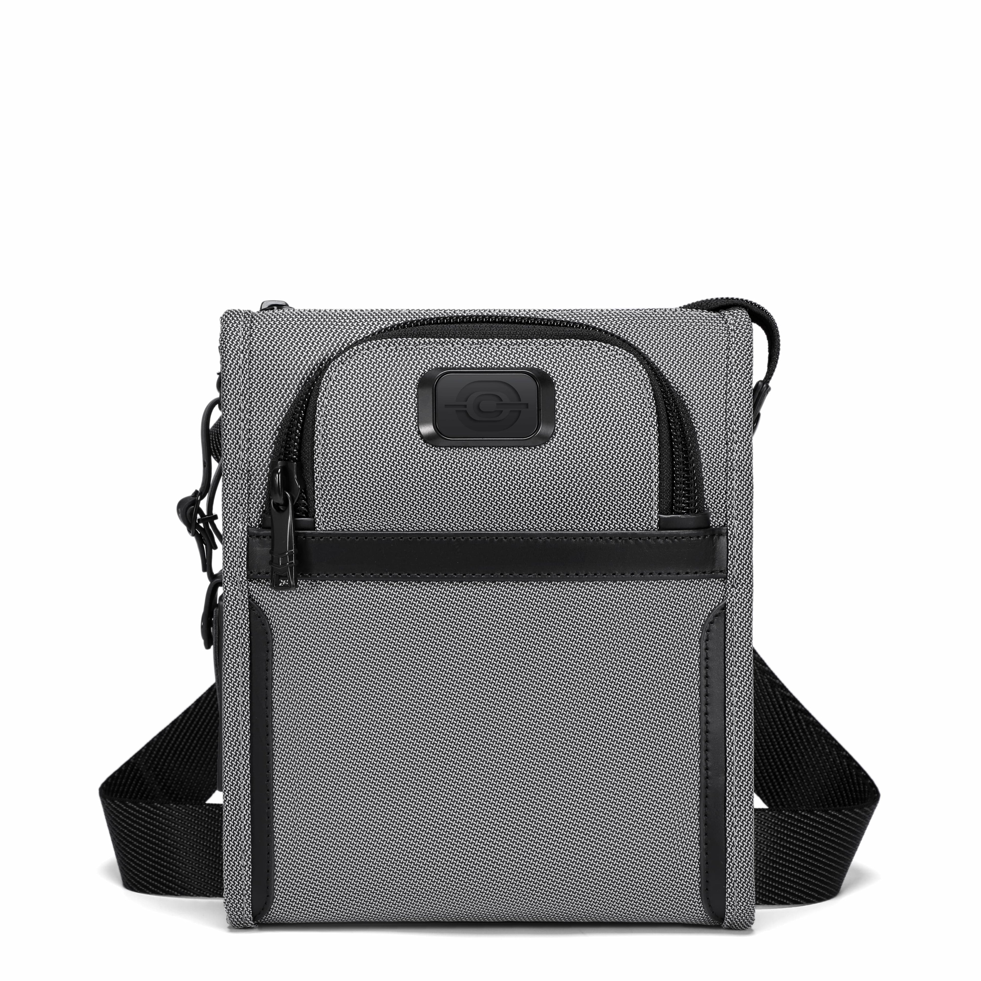 A gray and black crossbody tablet bag with a textured fabric body, black zippers, and an adjustable black shoulder strap, shown against a plain white background.