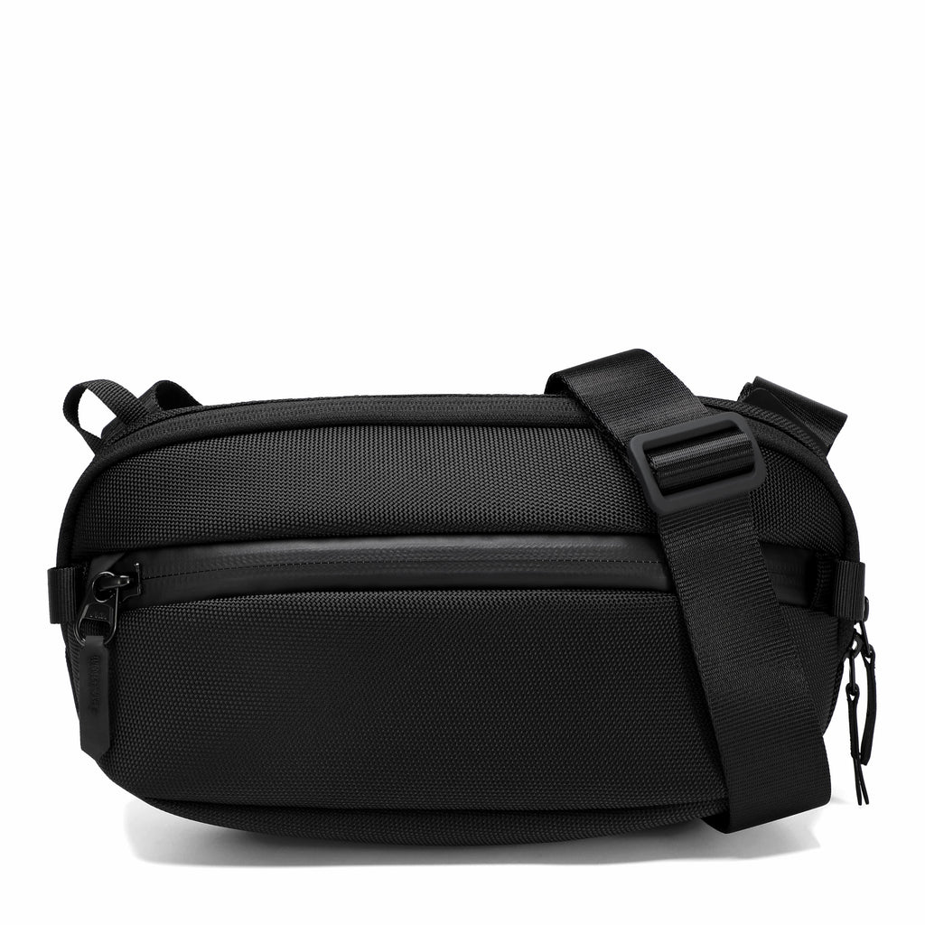 A black nylon crossbody bag with an adjustable shoulder strap and zippered compartments, shown on a clean white background.