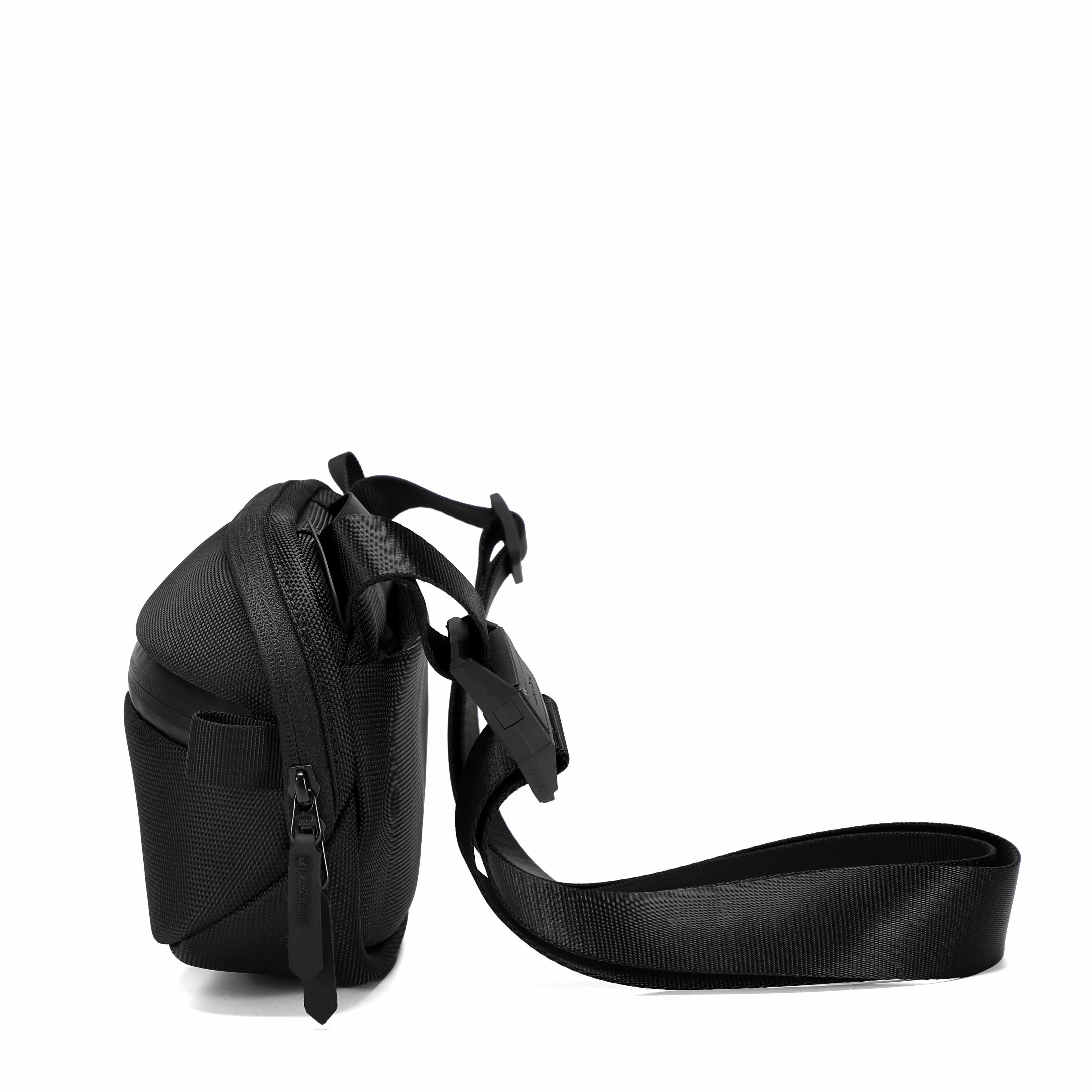 A black nylon crossbody bag with an adjustable shoulder strap, shown from a side profile view against a solid white background.