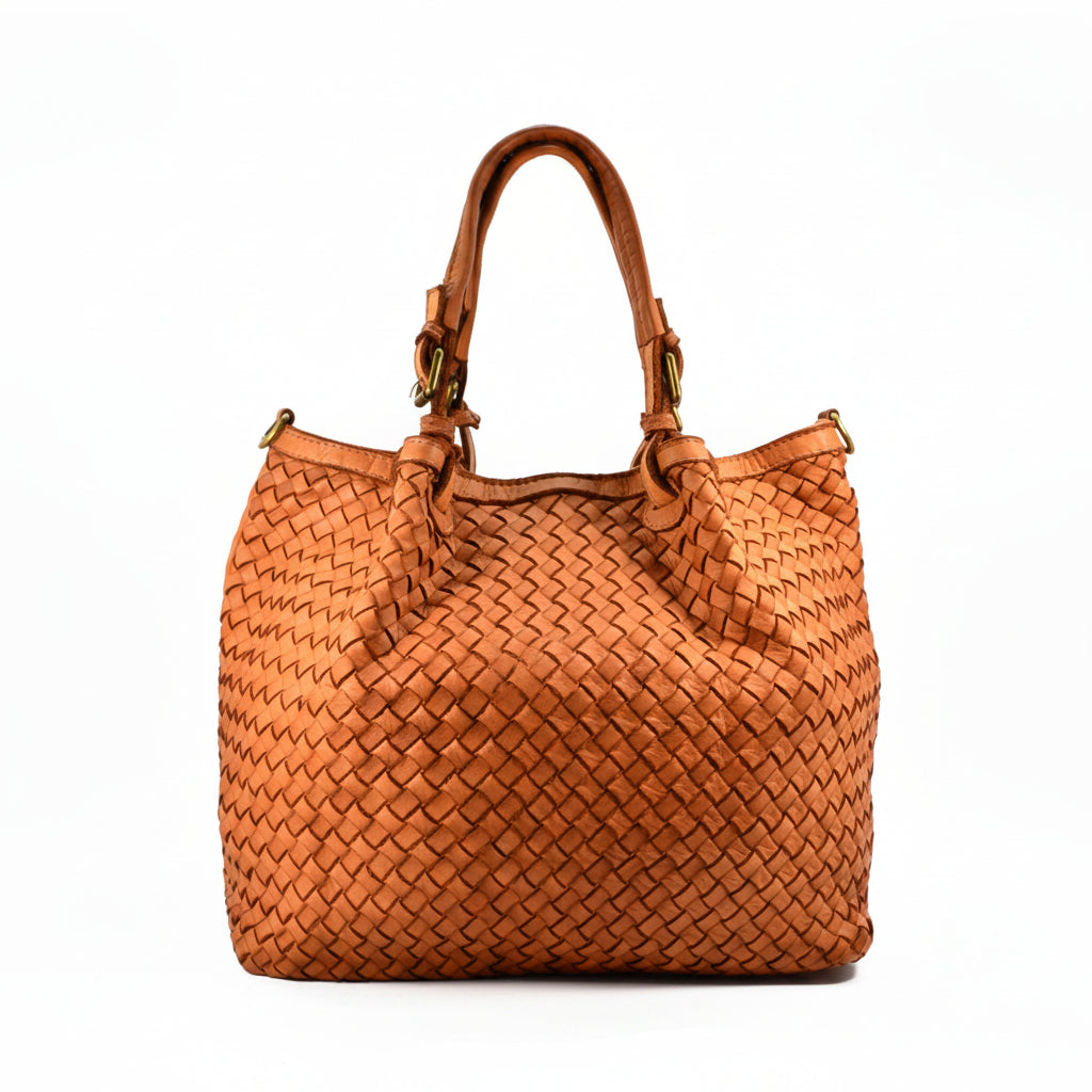 A woven leather handbag in a warm cognac brown, featuring dual top handles and gold-tone hardware, photographed against a solid white background.