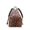 A brown leather backpack with dark brown shoulder straps and a front zipper closure, shown from the back on a white background.