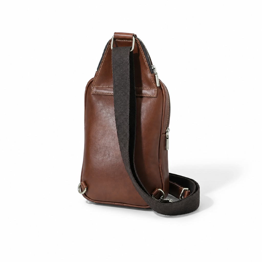 A brown leather crossbody bag with a black textured shoulder strap and silver-tone hardware, shown from a three-quarter angle on a white background.