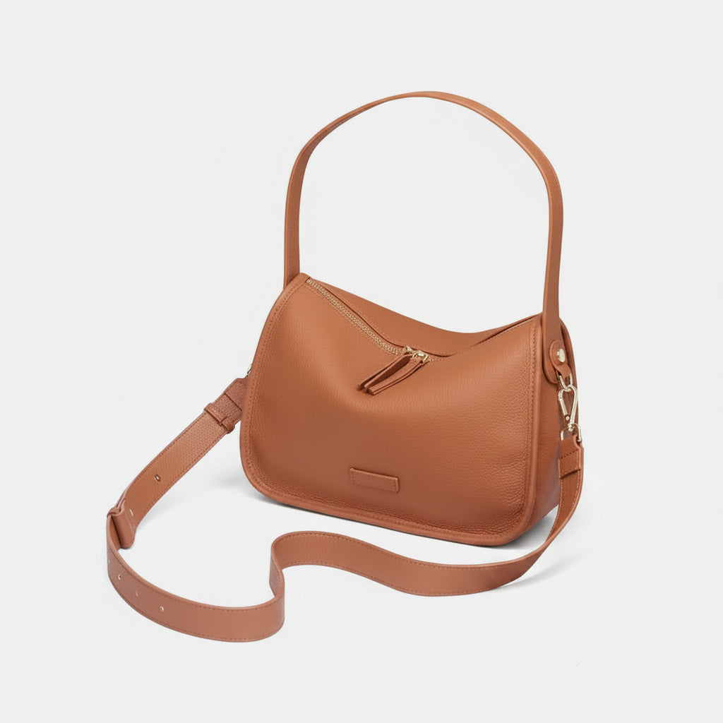 A tan leather shoulder bag with a top handle and an adjustable crossbody strap, shown on a plain white background.