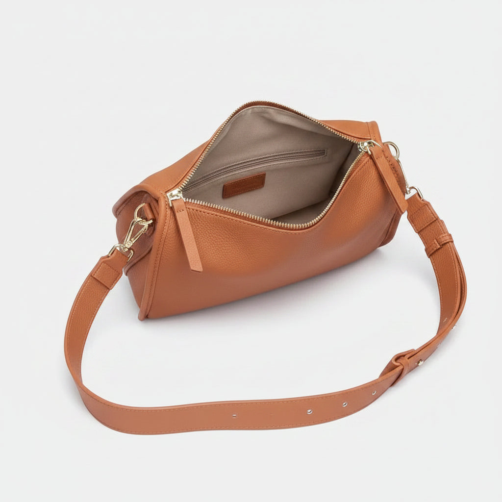 A tan leather shoulder bag shown open, with a matching adjustable shoulder strap and silver-tone hardware, photographed on a plain white background.